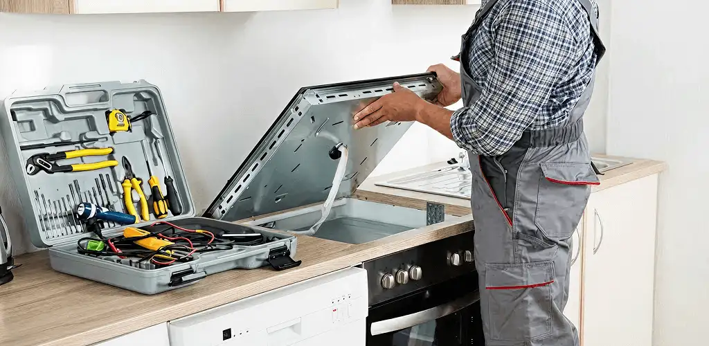 Handyman repairing a cooktop and checking wiring connections in Honolulu, HI