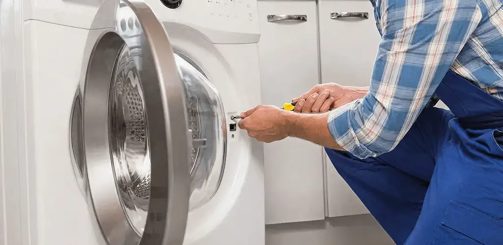 Handyman repairing a clothes dryer and checking electrical connections in Honolulu, HI