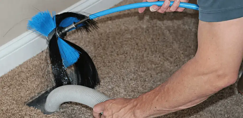Dryer vent cleaning technician brushing lint from a vent line in Honolulu, HI
