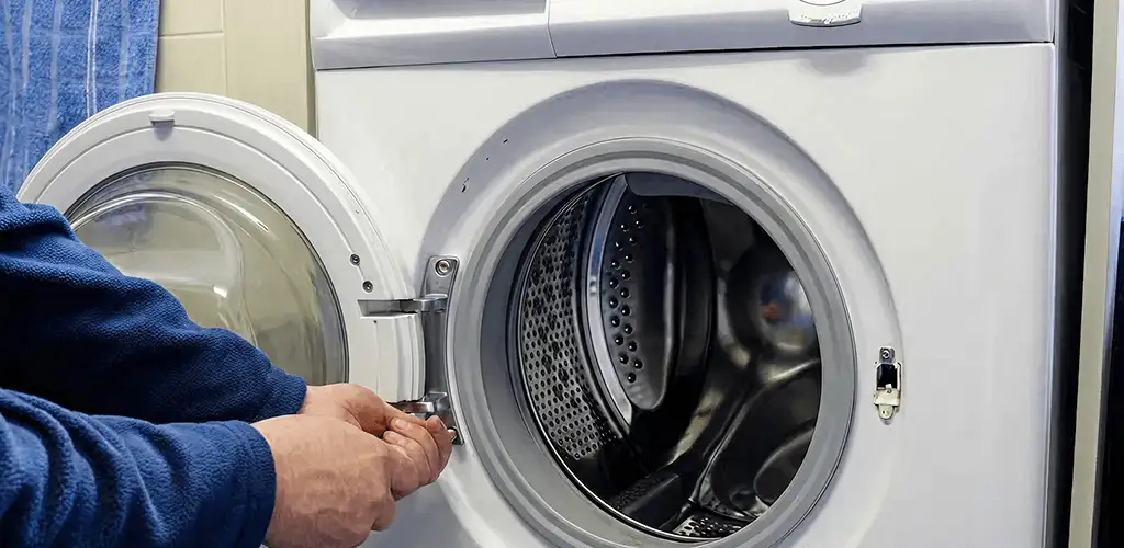 Washing machine repair handyman checking a front-load washer door and latch in Honolulu, HI