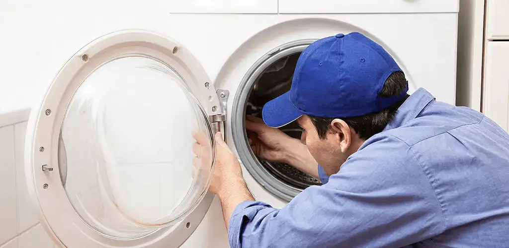 Washing machine repair handyman inspecting a front-load washer drum in Honolulu, HI