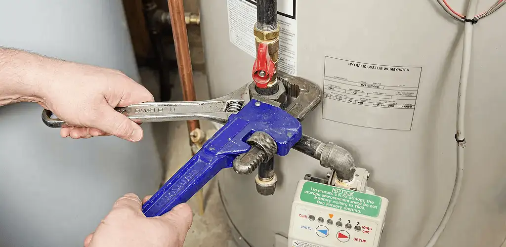 Water heater repair technician tightening the shutoff valve and supply line in Honolulu, HI